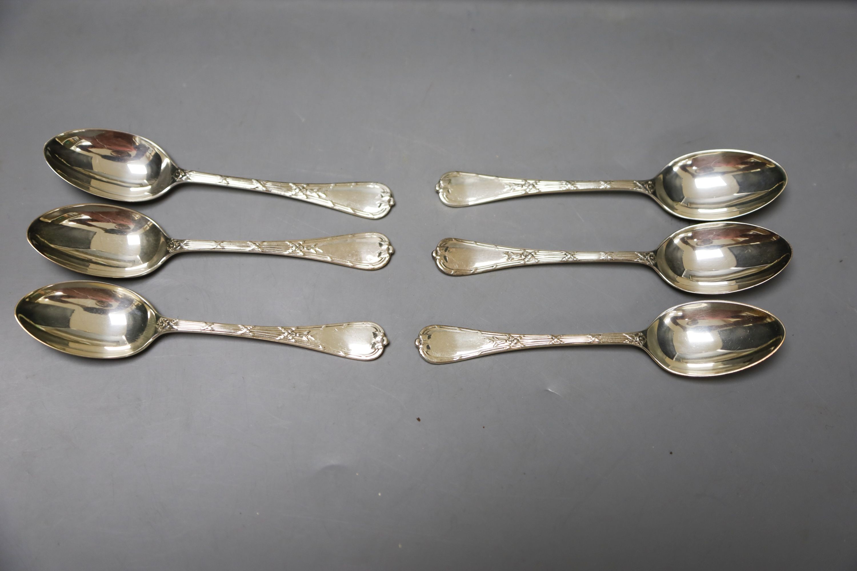 A set of six Aynsley coffee cans and saucers, with silver holders and a set of six silver spoons